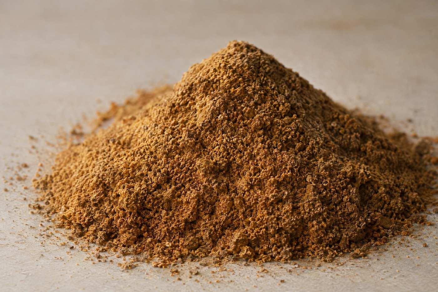 A heap of fine light-brown tobacco dust powder on a neutral surface