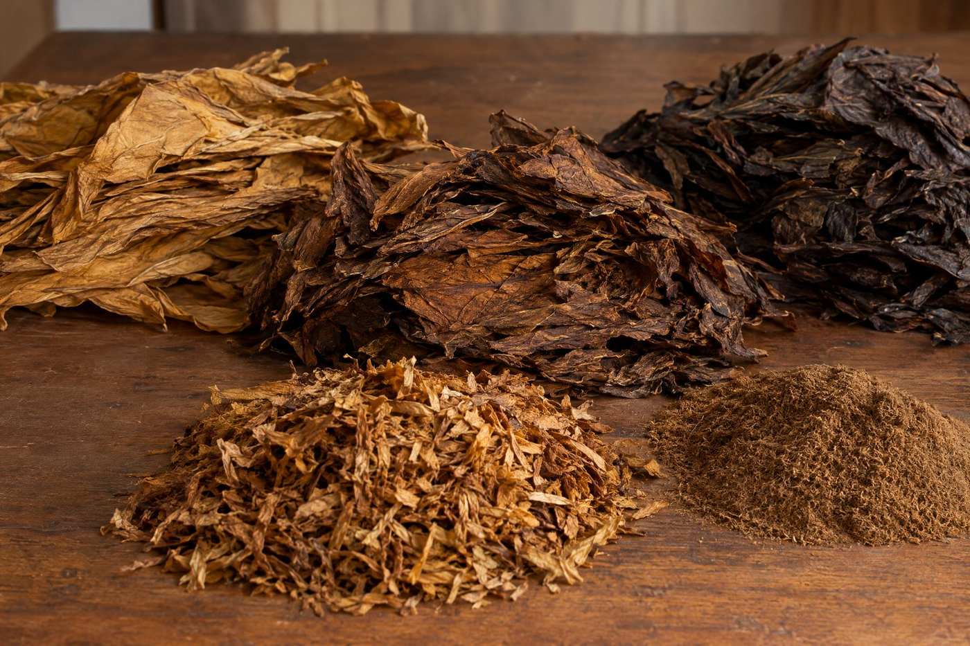 Hands sorting cured tobacco leaf on a table