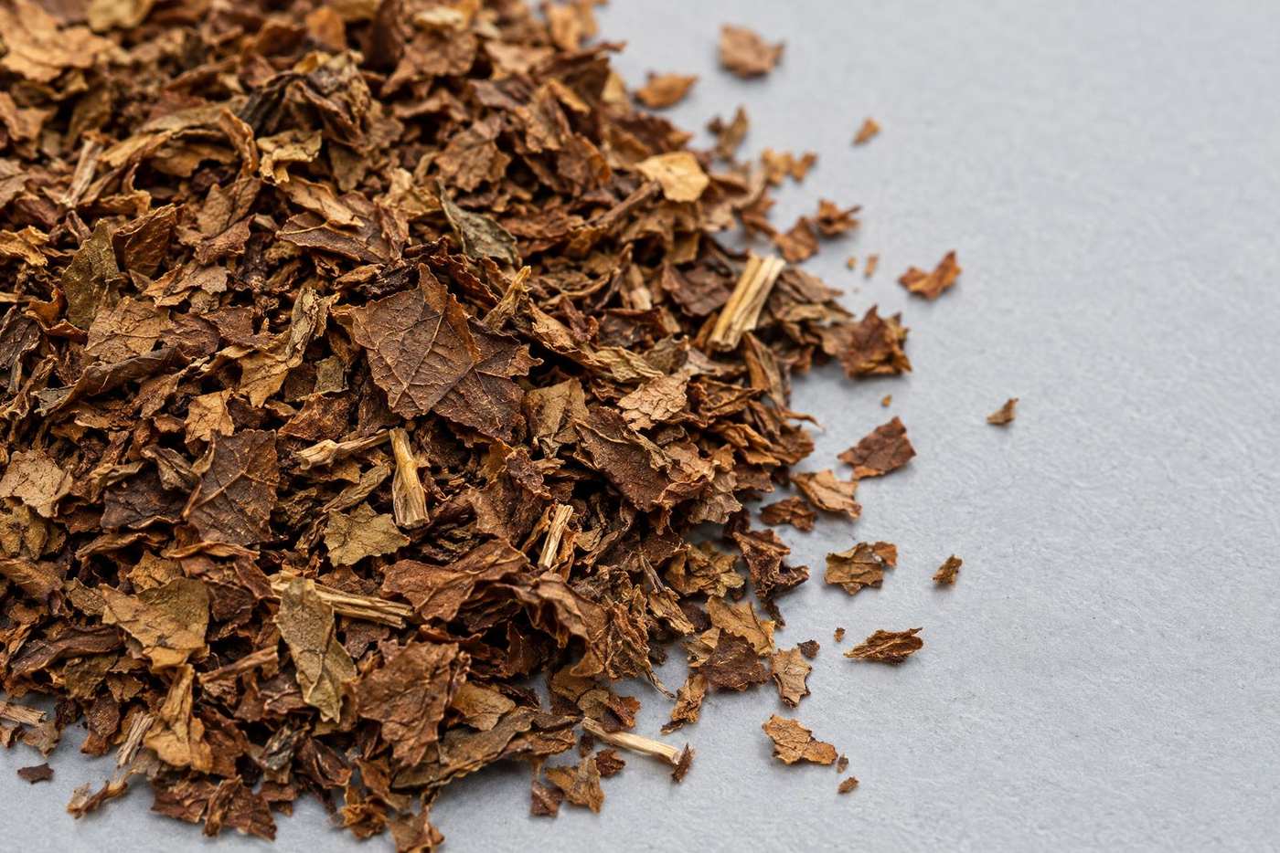 Close-up of dark-brown torn tobacco scrap pieces